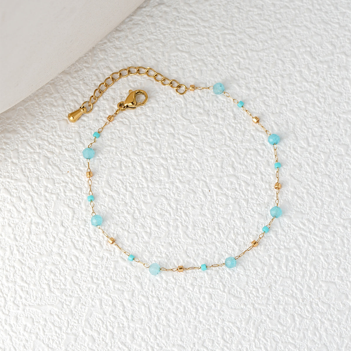 Light blue bead chain bracelet with gold-tone clasp and extender