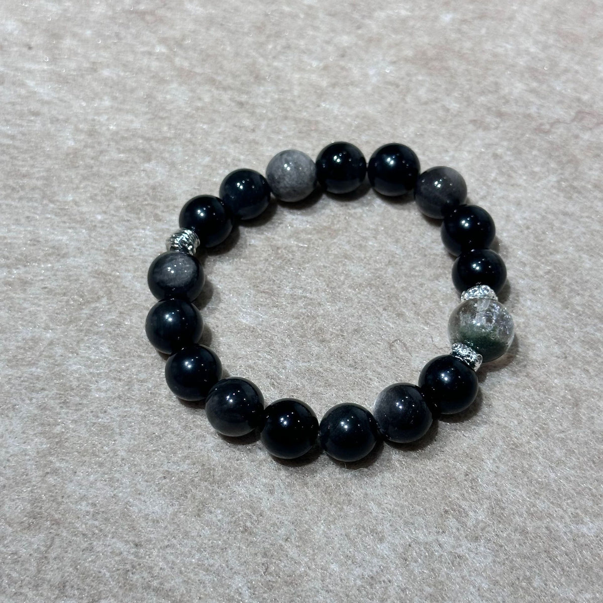Green and silver sheen bead bracelet on white